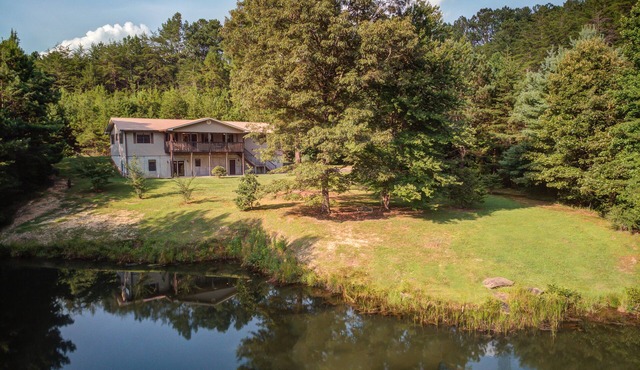 Pond-front cabin with private hot tub, fireplaces, furnished deck, & game room