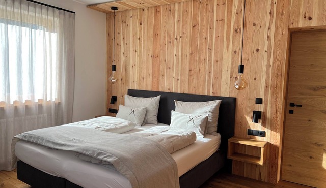 Spacious Alpine-style apartment with private garden and pool view.