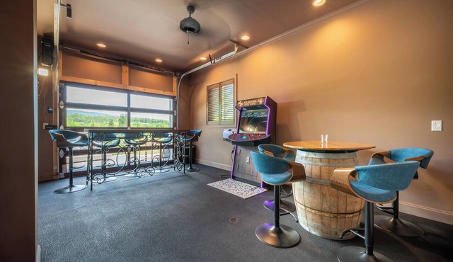 Welcome to this spectacular home, which stands out for its soaring stone fireplace, a bright sunroom, and a unique indoor-outdoor entertainment lounge with a classic arcade game!